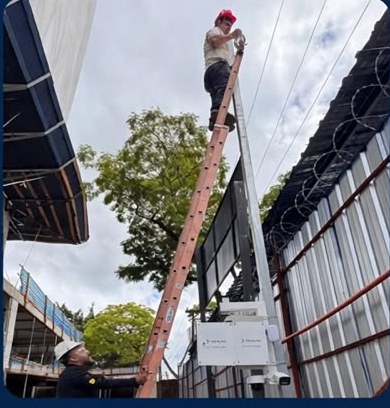 Técnico da Techlink instalando o módulo solar em um poste no canteiro de obra